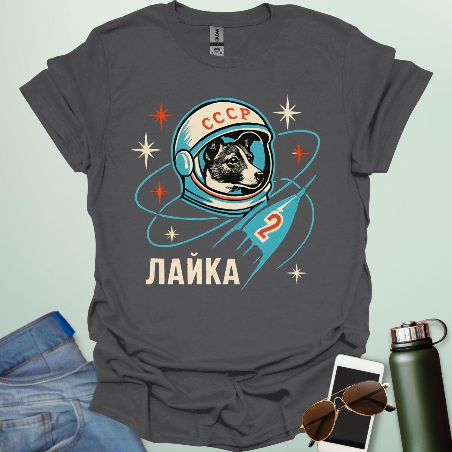 Laika First Dog in Space t-shirt with retro Soviet cosmonaut design featuring Laika in a helmet and rocket ship illustration.