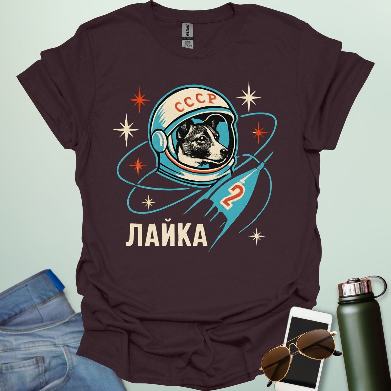 Laika First Dog in Space t-shirt with retro Soviet cosmonaut design featuring Laika in a helmet and rocket ship illustration.