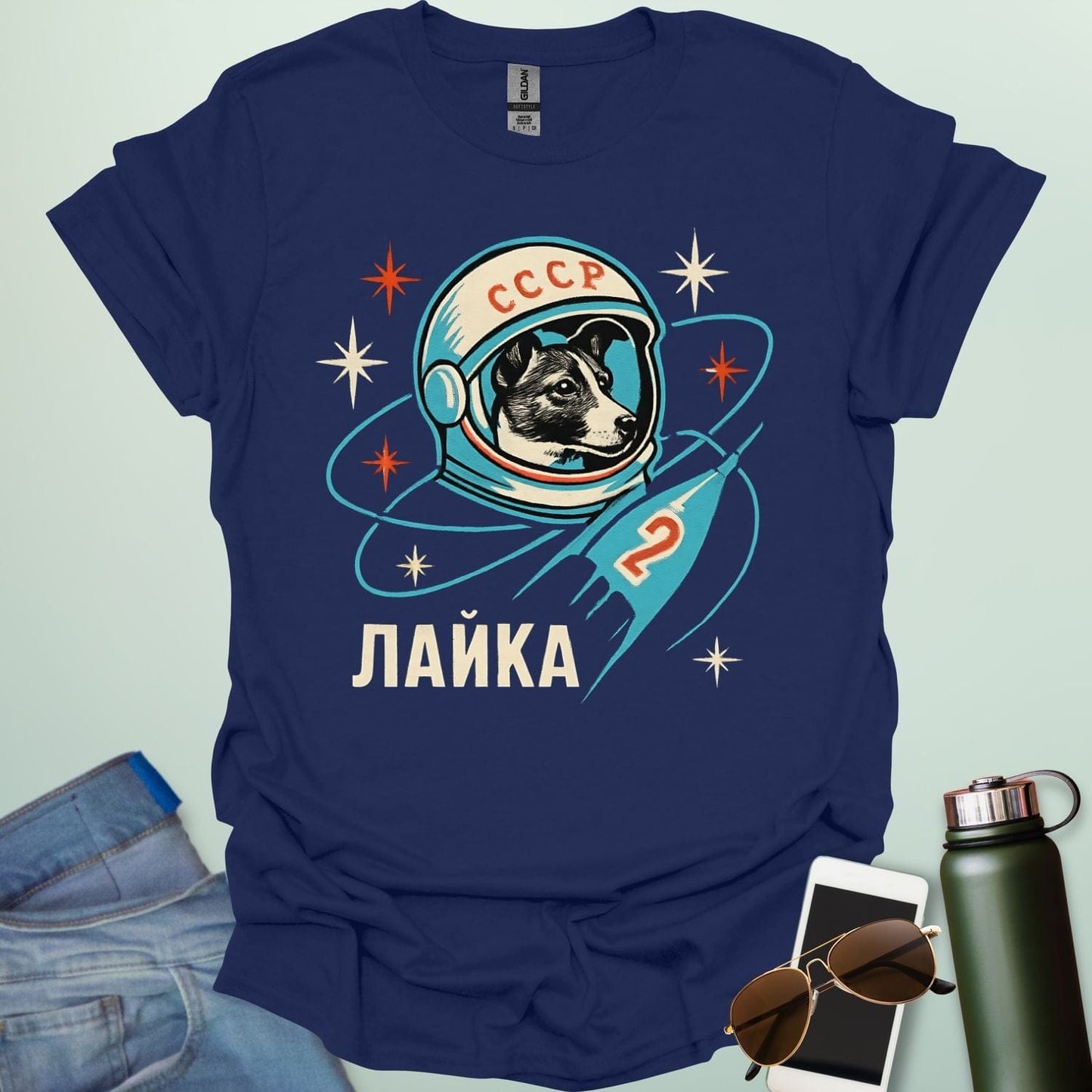 Laika First Dog in Space t-shirt with retro Soviet cosmonaut design featuring Laika in a helmet and rocket ship illustration.