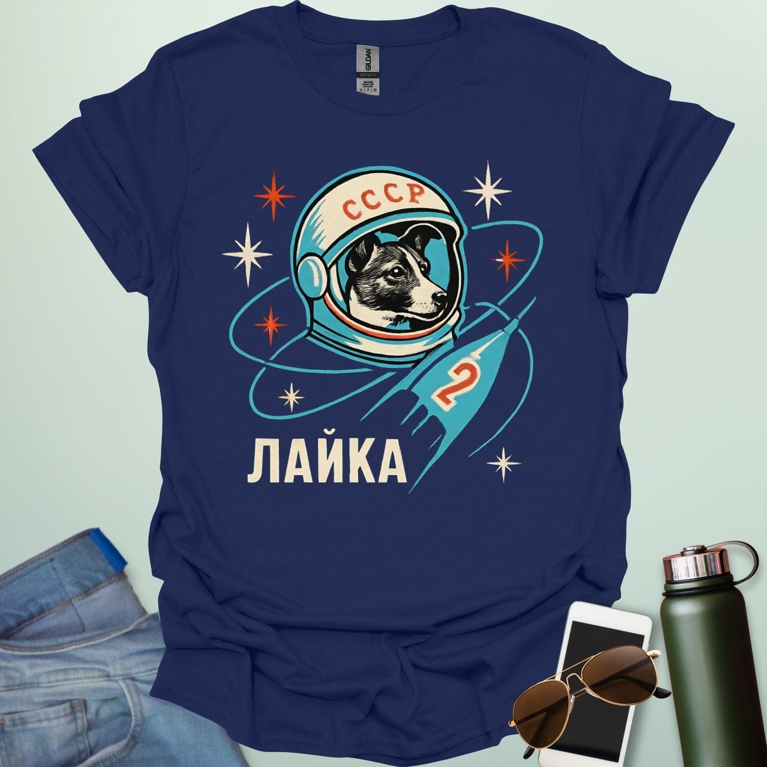 Laika First Dog in Space t-shirt with retro Soviet cosmonaut design featuring Laika in a helmet and rocket ship illustration.