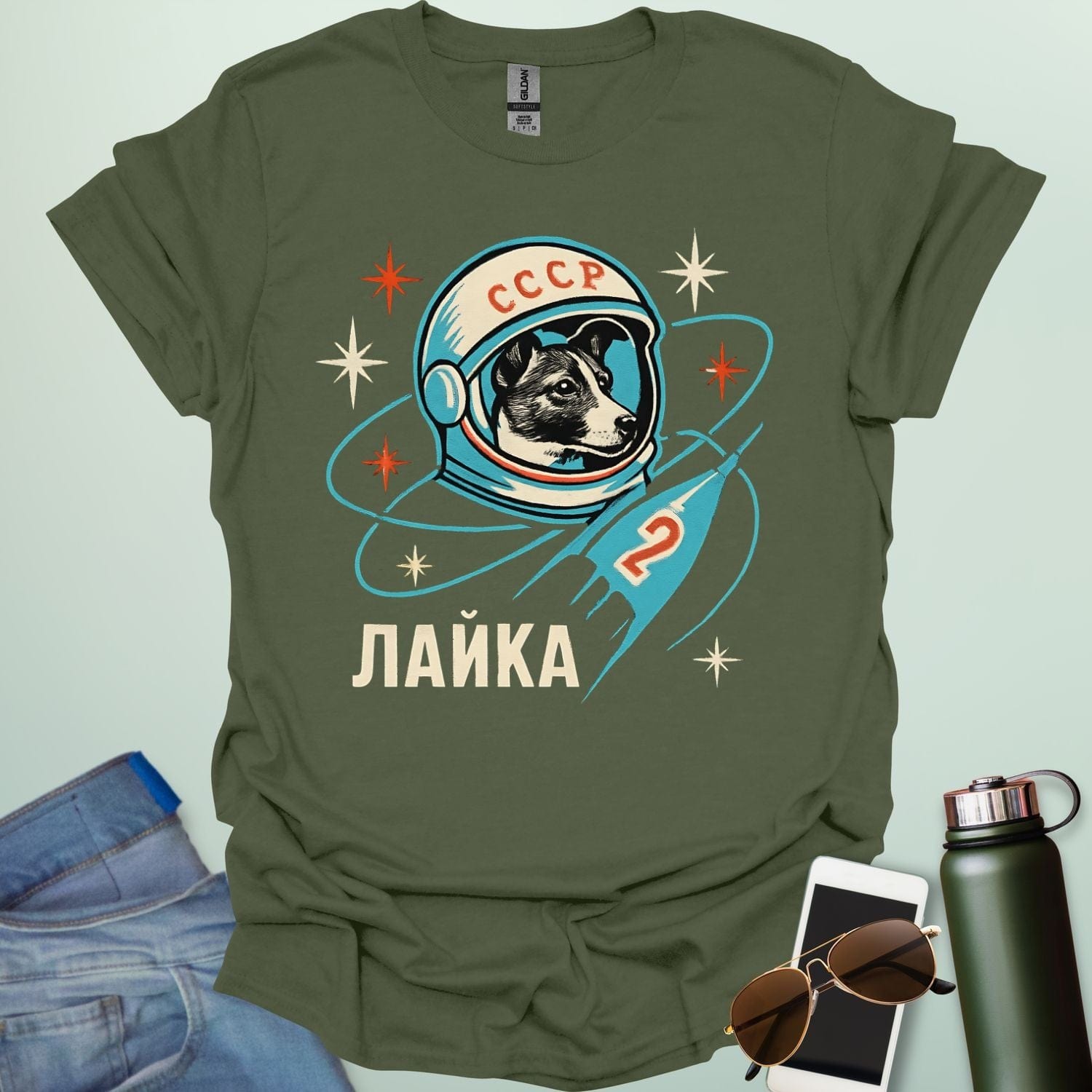 Laika First Dog in Space t-shirt with retro Soviet cosmonaut design featuring Laika in a helmet and rocket ship illustration.
