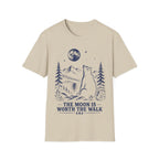 Vintage linocut-style illustration of a bear sitting beside a backpack, gazing up at a full moon over mountains and pine trees with text reading 'THE MOON IS WORTH THE WALK'.