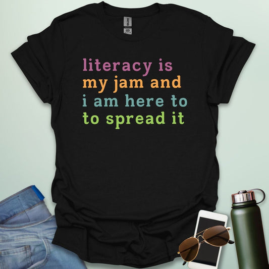 Black T-shirt with the text 'literacy is my jam and i'm here to spread it' in colorful, bold lettering.