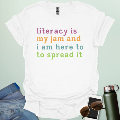 White T-shirt with the text 'literacy is my jam and i'm here to spread it' in colorful, bold lettering.