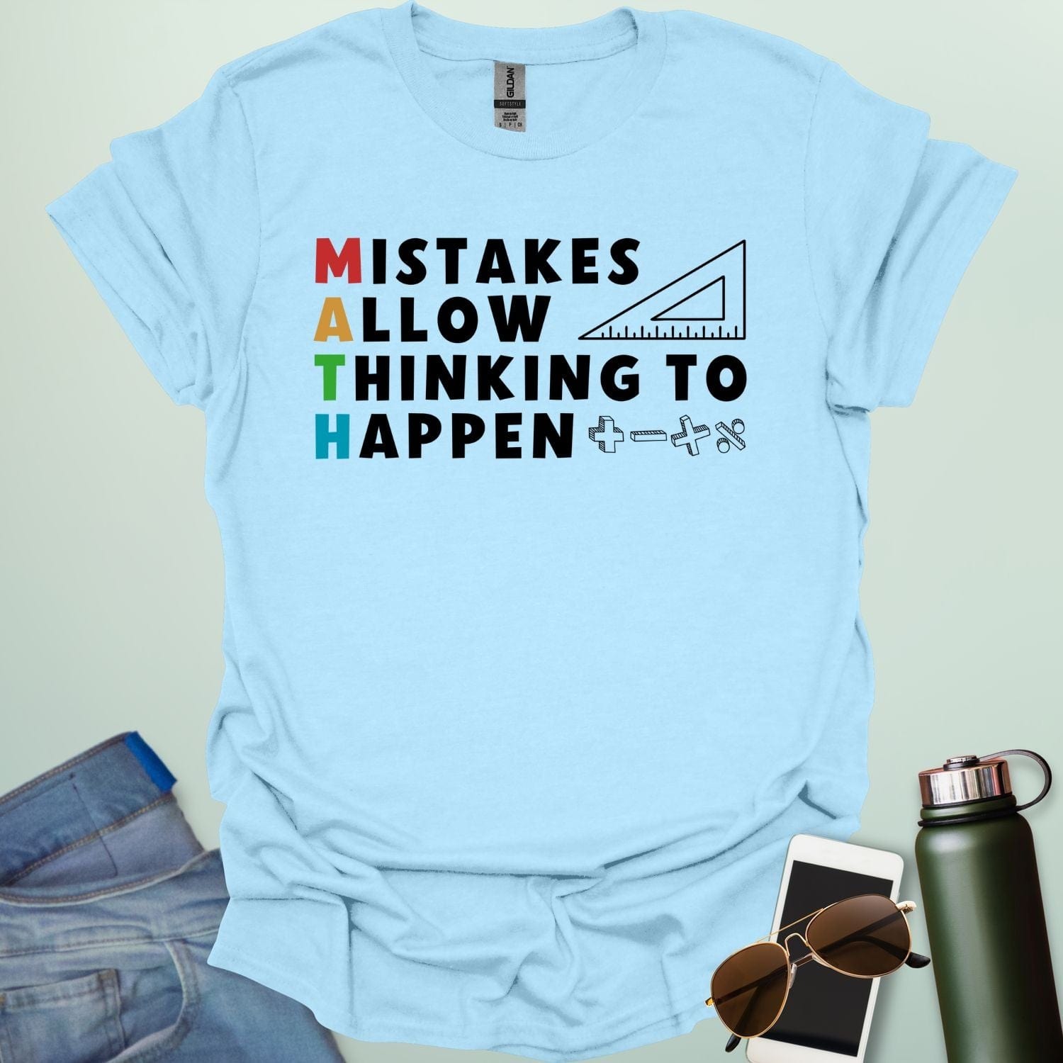 A light blue t-shirt with the text 'MISTAKES ALLOW THINKING TO HAPPEN,' with the first letter of each word forming 'MATH' vertically, and a ruler and math symbols.