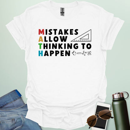 A white t-shirt with the text 'MISTAKES ALLOW THINKING TO HAPPEN,' with the first letter of each word forming 'MATH' vertically, and a ruler and math symbols.