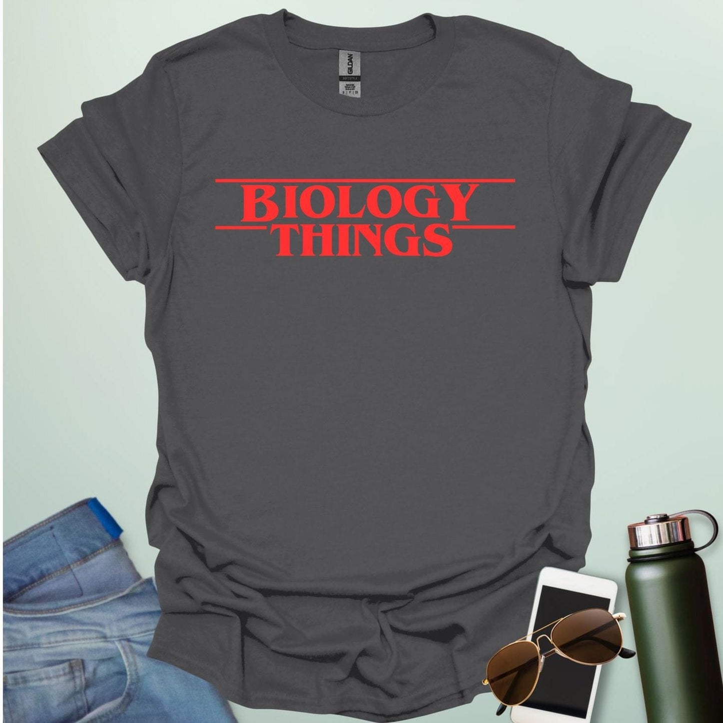 The words 'BIOLOGY' stacked above 'THINGS' in a red, stylized font with horizontal lines above and below, as a parody of the 'Stranger Things' logo.