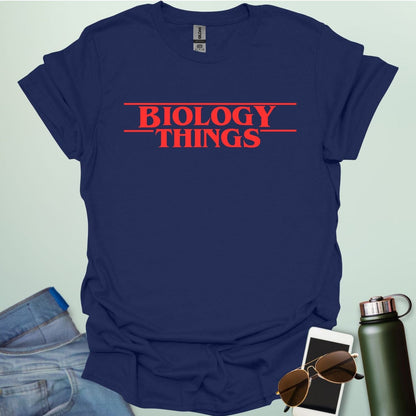 The words 'BIOLOGY' stacked above 'THINGS' in a red, stylized font with horizontal lines above and below, as a parody of the 'Stranger Things' logo.