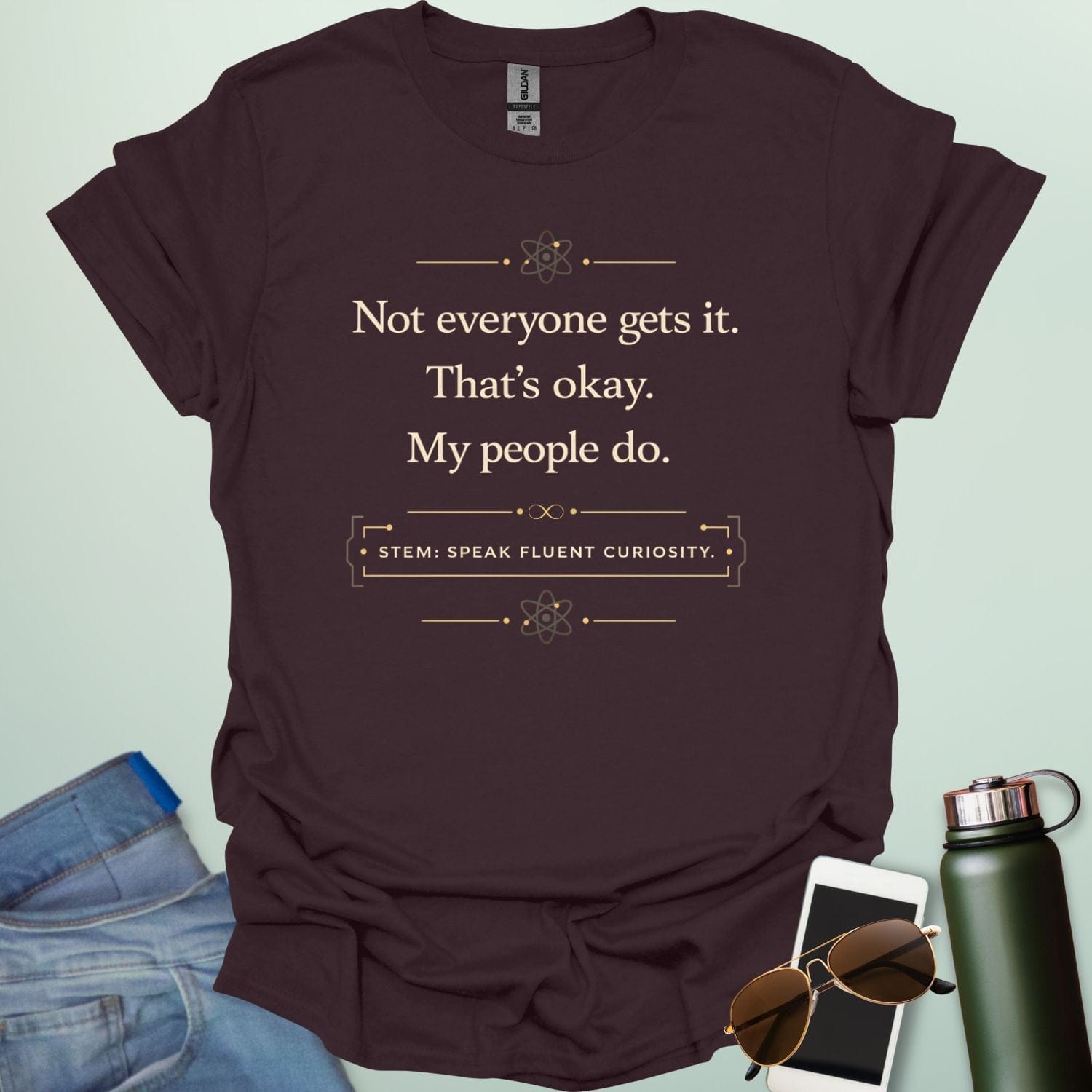 T-shirt with navy blue text reading 'Not everyone gets it. That's okay. My people do.' and 'STEM: SPEAK FLUENT CURIOSITY' with atom icons."