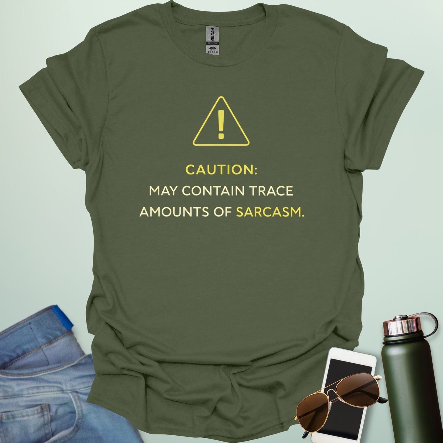 A minimalist science-themed design featuring a warning triangle with an "!" in the center with text "CAUTION: MAY CONTAIN TRACE AMOUNTS OF SARCASM" underneath.