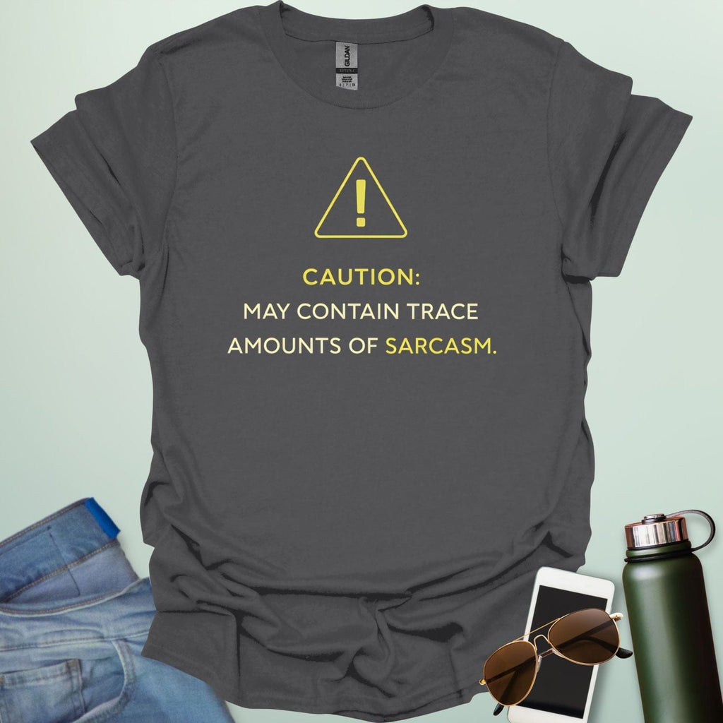 A minimalist science-themed design featuring a warning triangle with an "!" in the center with text "CAUTION: MAY CONTAIN TRACE AMOUNTS OF SARCASM" underneath.