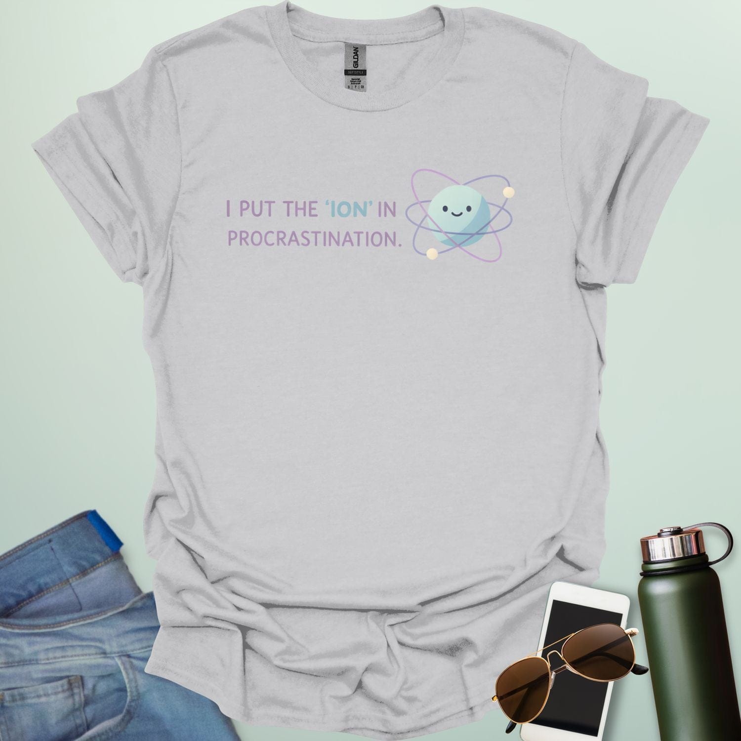 A playful science graphic featuring an atom or ion illustration with the punny text "I PUT THE 'ION' IN PROCRASTINATION" in a modern, rounded typeface.