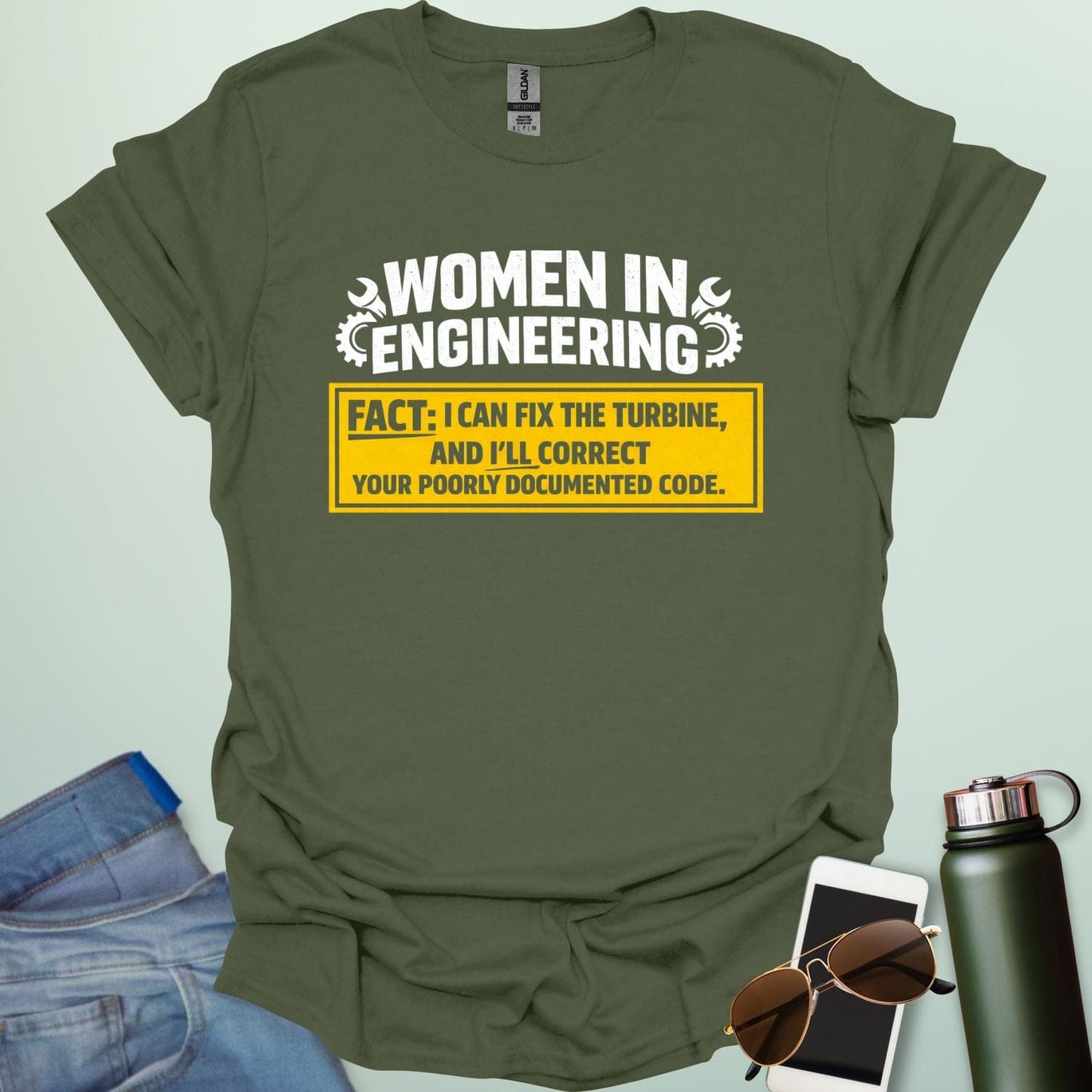Graphic design featuring the text 'WOMEN IN ENGINEERING' with wrench and gear icons above a yellow box reading 'FACT: I CAN FIX THE TURBINE, AND I’LL CORRECT YOUR POORLY DOCUMENTED CODE.'