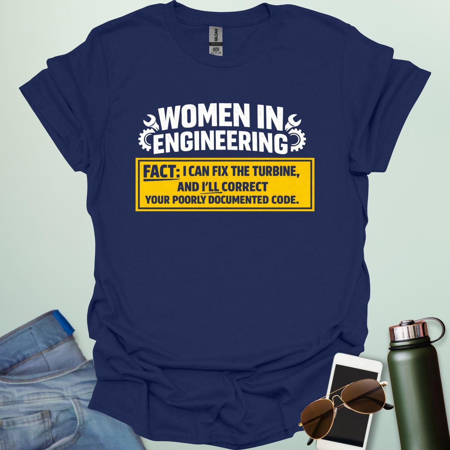 Graphic design featuring the text 'WOMEN IN ENGINEERING' with wrench and gear icons above a yellow box reading 'FACT: I CAN FIX THE TURBINE, AND I’LL CORRECT YOUR POORLY DOCUMENTED CODE.'