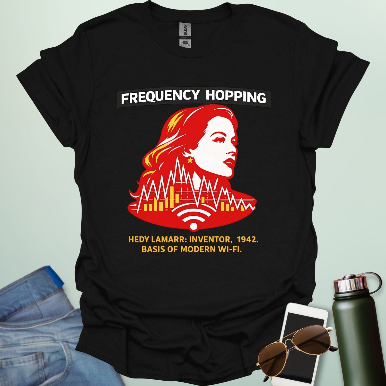 Graphic design featuring a stylized red and yellow portrait of Hedy Lamarr with signal wave patterns, Wi-Fi icons, and text reading 'FREQUENCY HOPPING' and 'HEDY LAMARR: INVENTOR, 1942. BASIS OF MODERN WI-FI.'