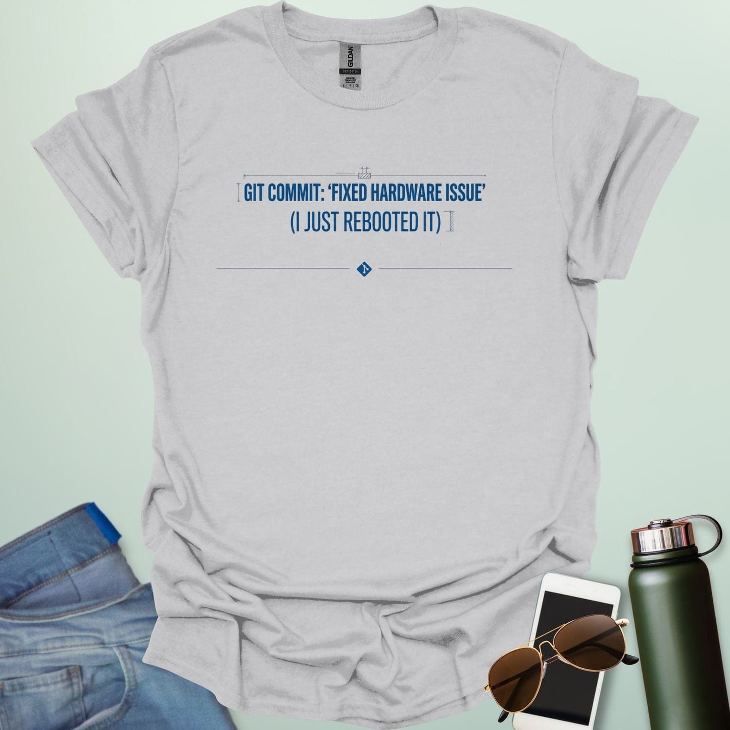 Graphic design featuring the text 'GIT COMMIT: FIXED HARDWARE ISSUE (I JUST REBOOTED IT)' with a Git logo icon and stylized coding bracket accents.