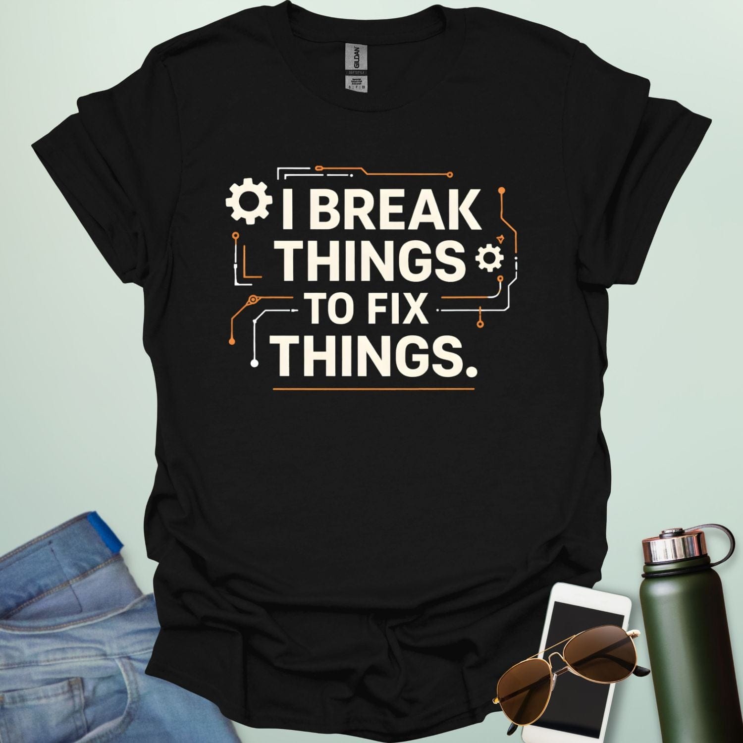 Graphic t-shirt design featuring bold text that reads 'I BREAK THINGS TO FIX THINGS' accented with mechanical gears and electronic circuit board line art.