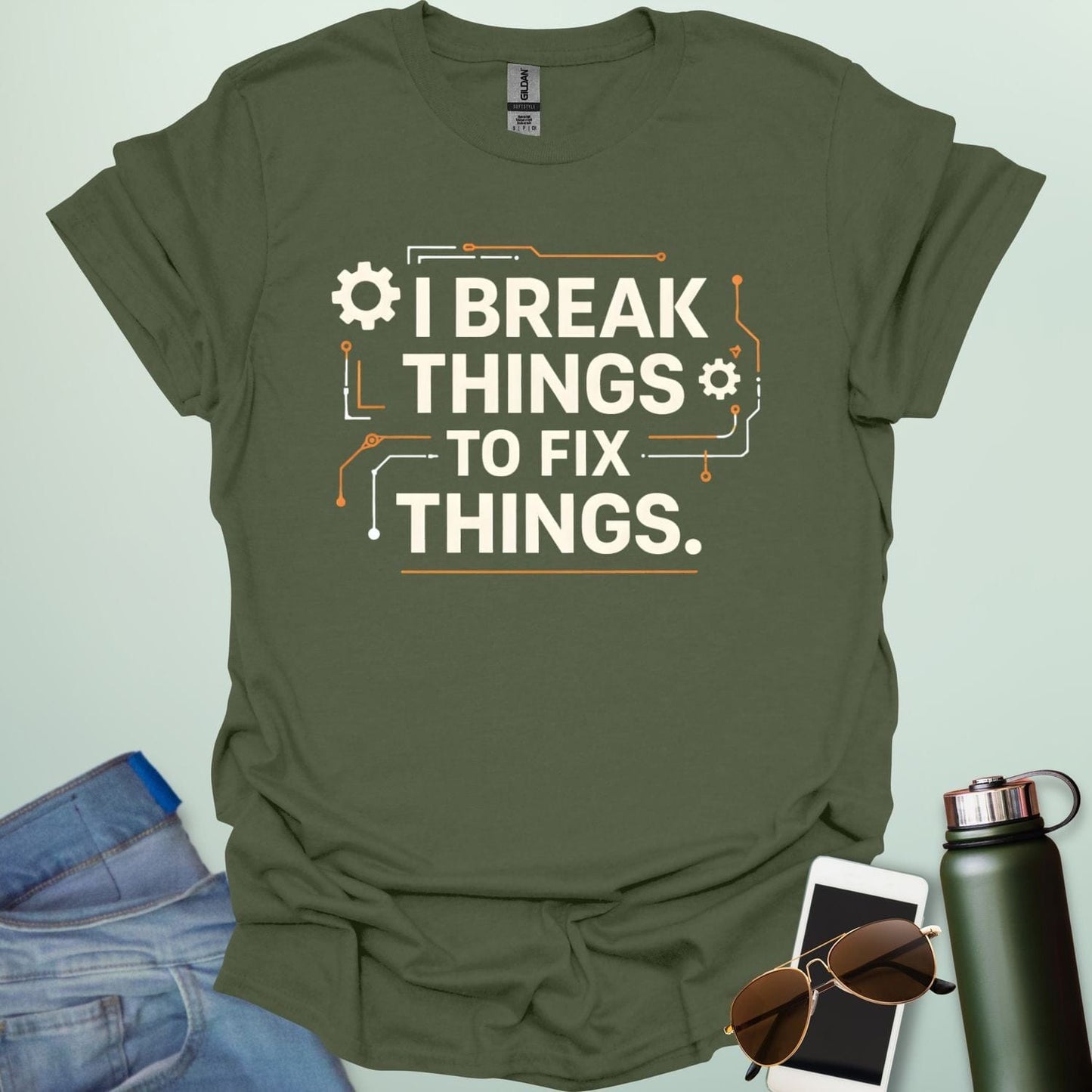 Graphic t-shirt design featuring bold text that reads 'I BREAK THINGS TO FIX THINGS' accented with mechanical gears and electronic circuit board line art.