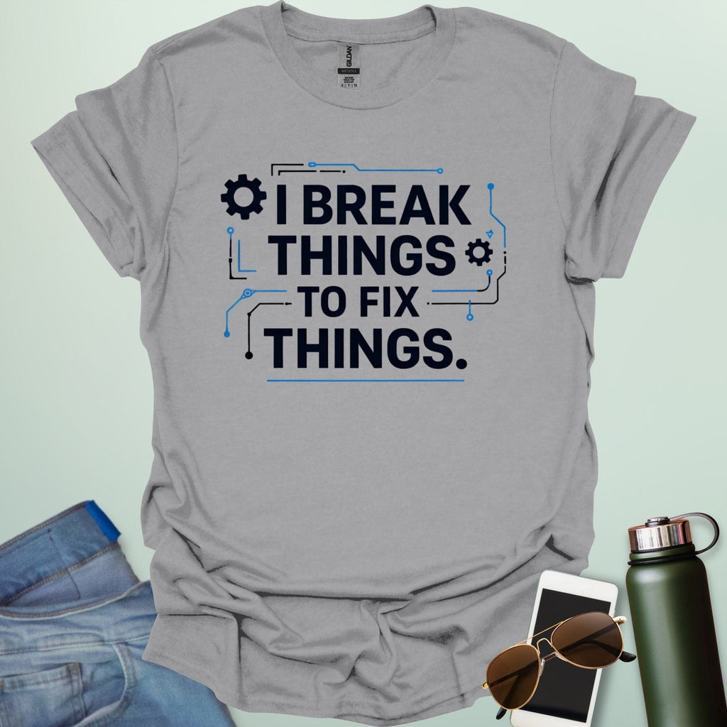 Graphic t-shirt design featuring bold text that reads 'I BREAK THINGS TO FIX THINGS' accented with mechanical gears and electronic circuit board line art.