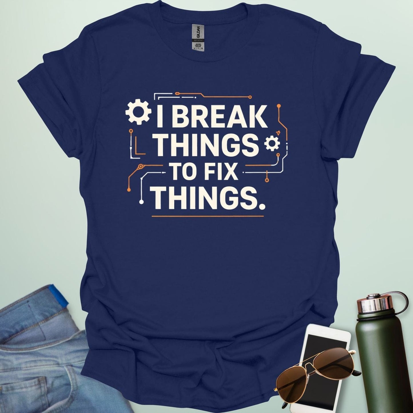 Graphic t-shirt design featuring bold text that reads 'I BREAK THINGS TO FIX THINGS' accented with mechanical gears and electronic circuit board line art.