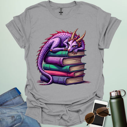 Dragon Fantasy t-shirt featuring whimsical purple dragon curled on a stack of books — perfect for fantasy fans, book lovers, and story geeks.