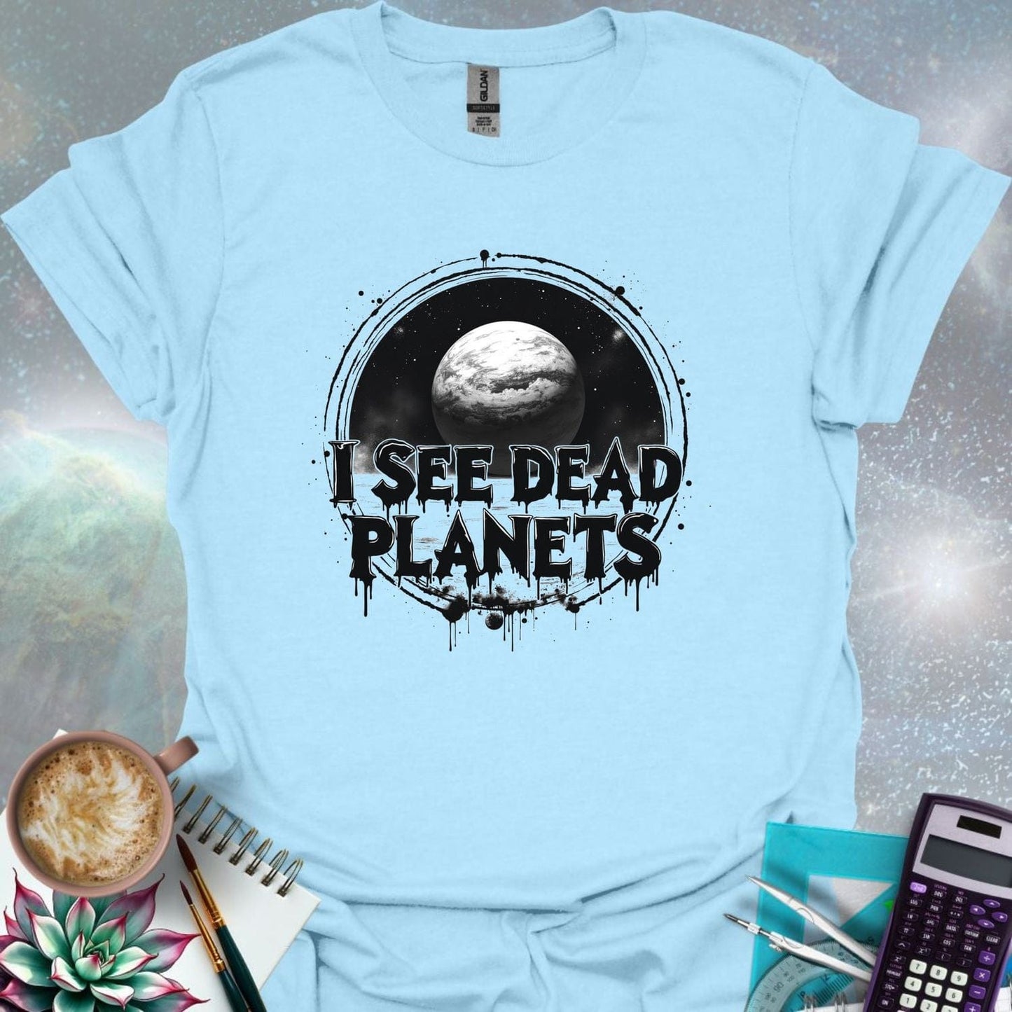 T-shirt design featuring a planet with the text 'I See Dead Planets' in a distressed, gothic font, with splatters and a dark, space-themed background.