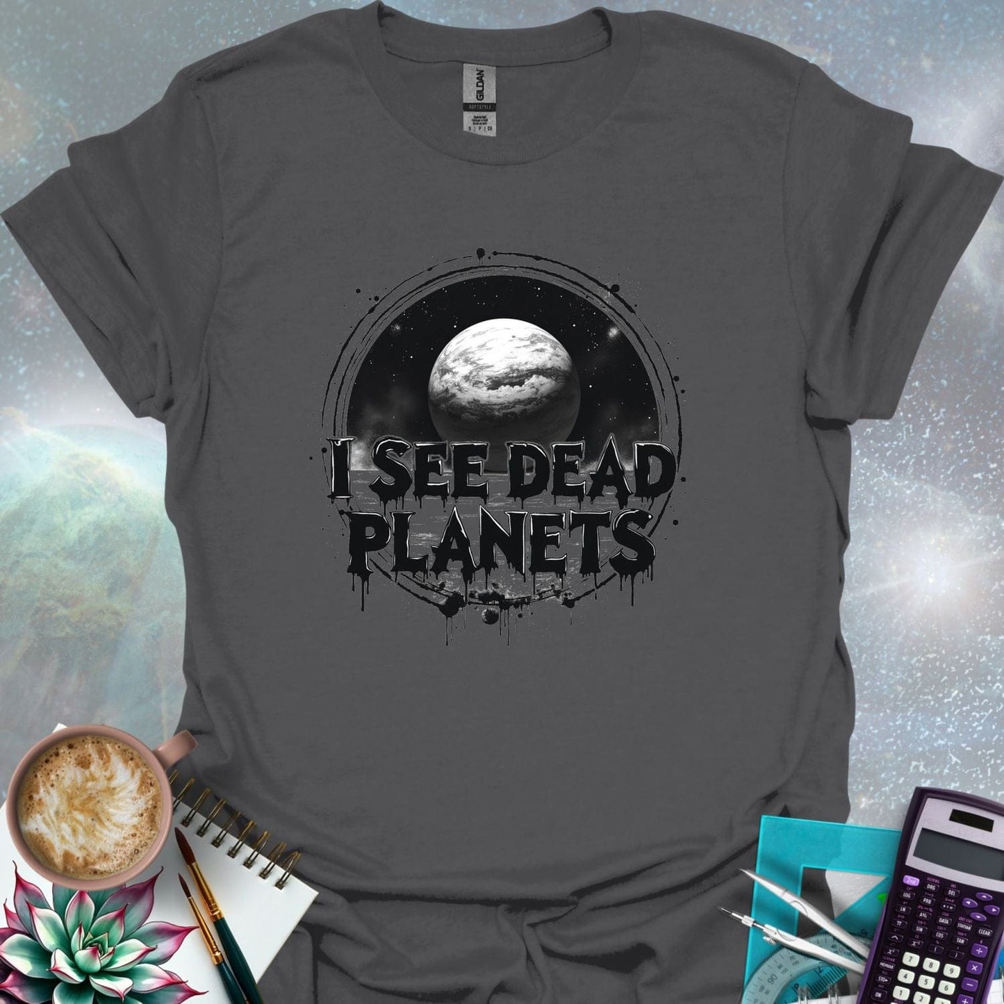 T-shirt design featuring a planet with the text 'I See Dead Planets' in a distressed, gothic font, with splatters and a dark, space-themed background.