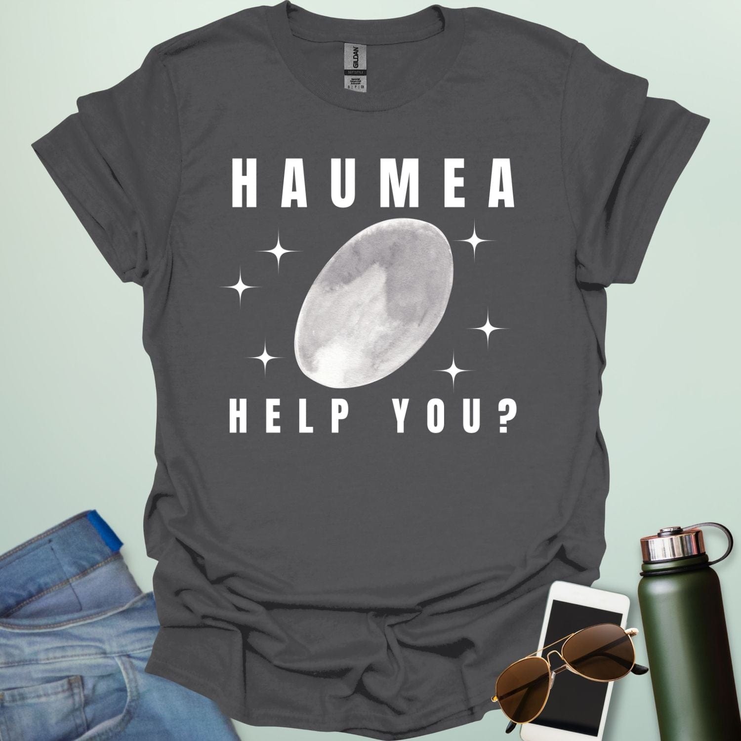 "A charcoal grey t-shirt with a drawing of the dwarf planet Haumea and the text 'HAUMEA HELP YOU?'