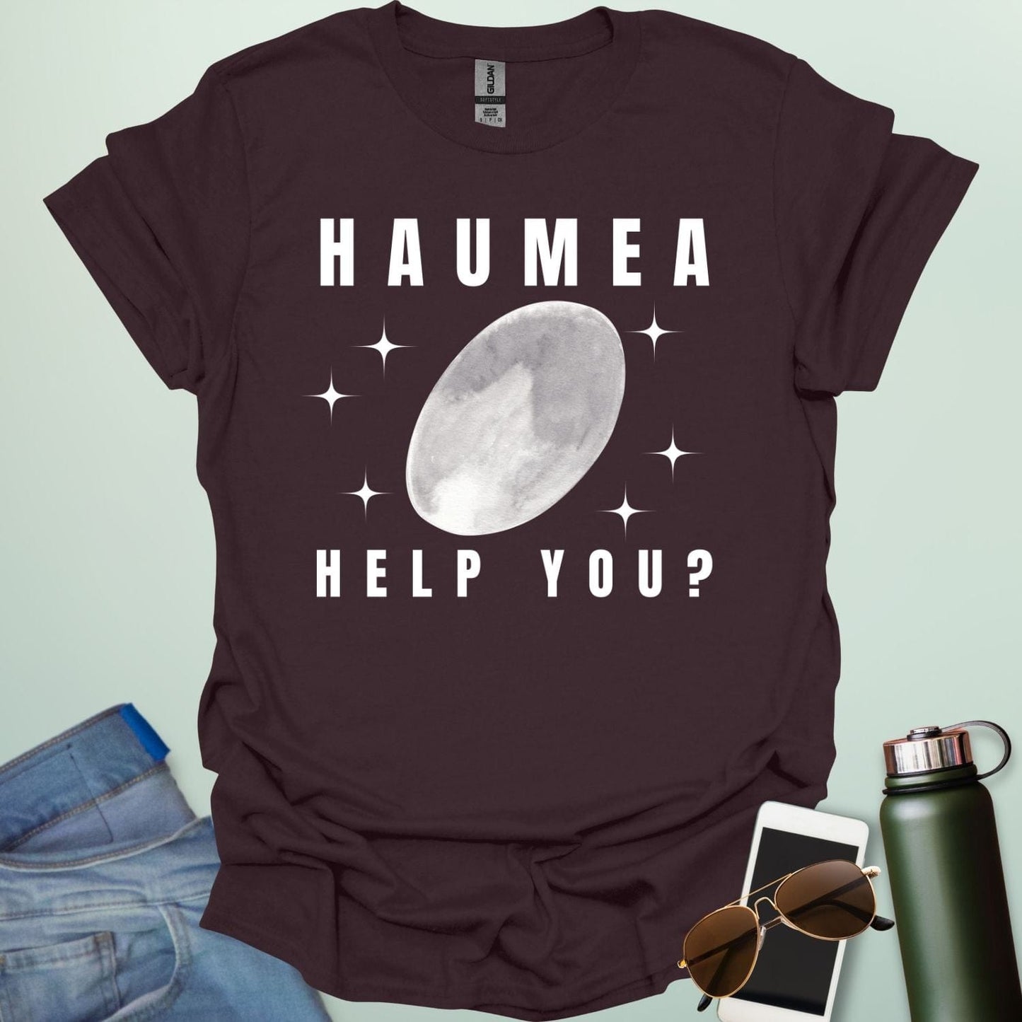 "A dark chocolate t-shirt with a drawing of the dwarf planet Haumea and the text 'HAUMEA HELP YOU?'
