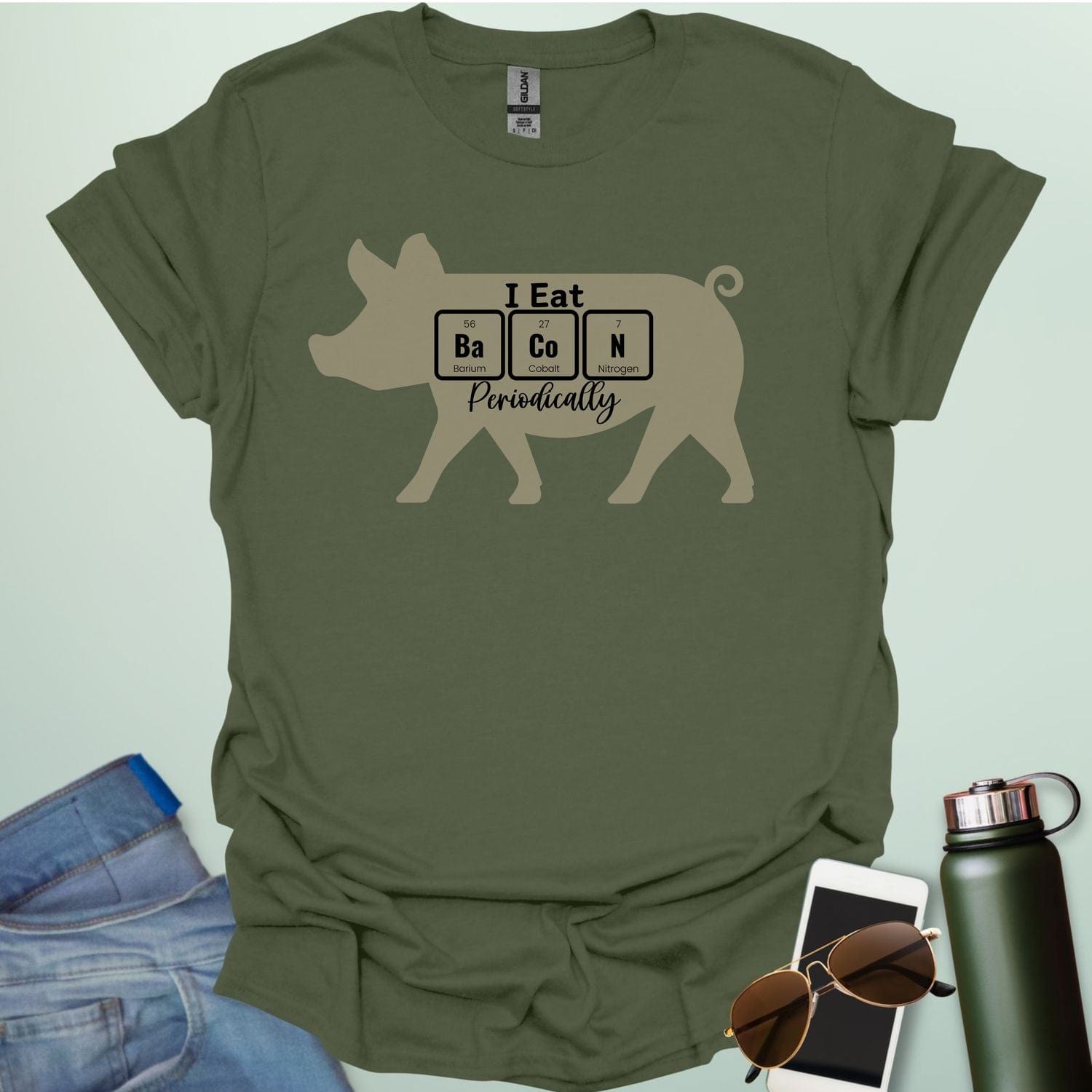 T-shirt design featuring a pig silhouette with the text 'I Eat Bacon Periodically,' where 'Bacon' is spelled using periodic table element symbols.