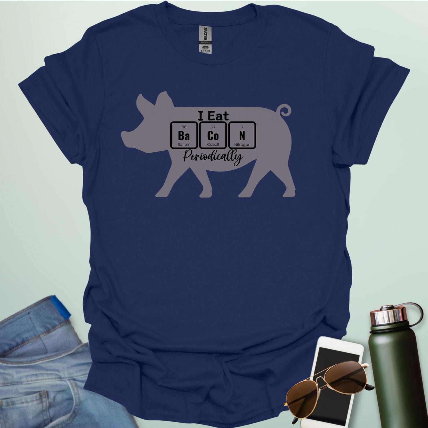 T-shirt design featuring a pig silhouette with the text 'I Eat Bacon Periodically,' where 'Bacon' is spelled using periodic table element symbols.