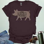 T-shirt design featuring a pig silhouette with the text 'I Eat Bacon Periodically,' where 'Bacon' is spelled using periodic table element symbols.