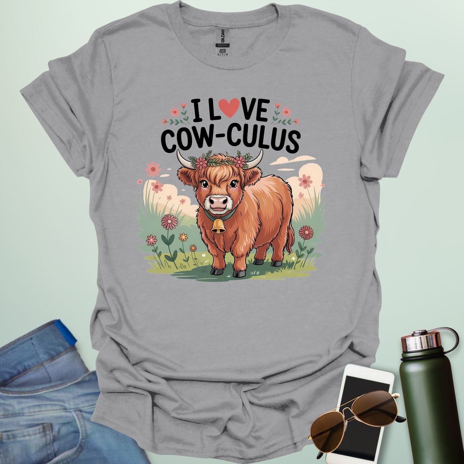 A sport grey t-shirt with a cute illustration of a cow in a field and the text 'I love Cow-culus' with a heart symbol.