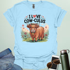 A light blue t-shirt with a cute illustration of a cow in a field and the text 'I love Cow-culus' with a heart symbol.