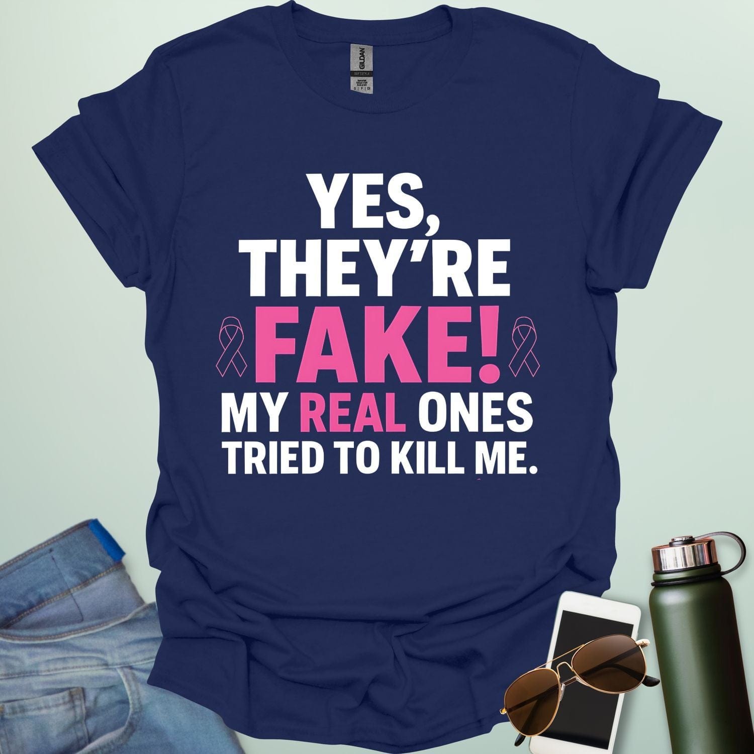 ‘Yes, They’re Fake — My Real Ones Tried to Kill Me’ t-shirt design with bold typography — breast cancer awareness & survivorship statement shirt.