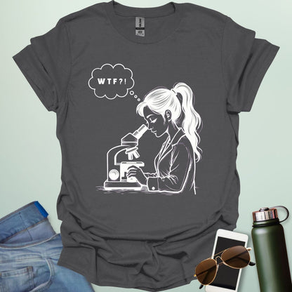 A funny t-shirt for scientists with a line drawing of a woman looking through a microscope and a thought bubble with the text 'WTF?!'