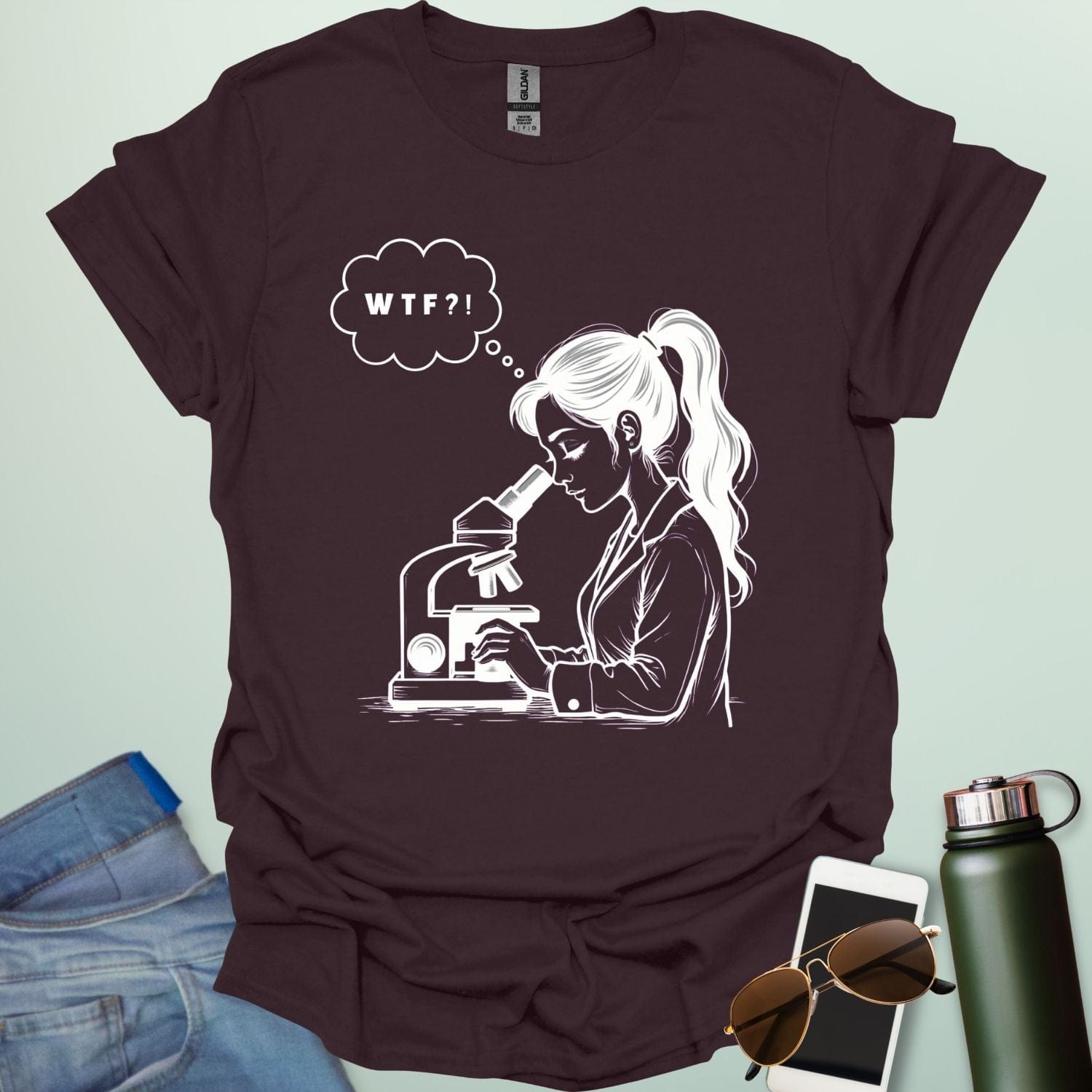 A funny t-shirt for scientists with a line drawing of a woman looking through a microscope and a thought bubble with the text 'WTF?!'