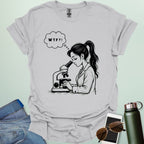 A funny t-shirt for scientists with a line drawing of a woman looking through a microscope and a thought bubble with the text 'WTF?!'