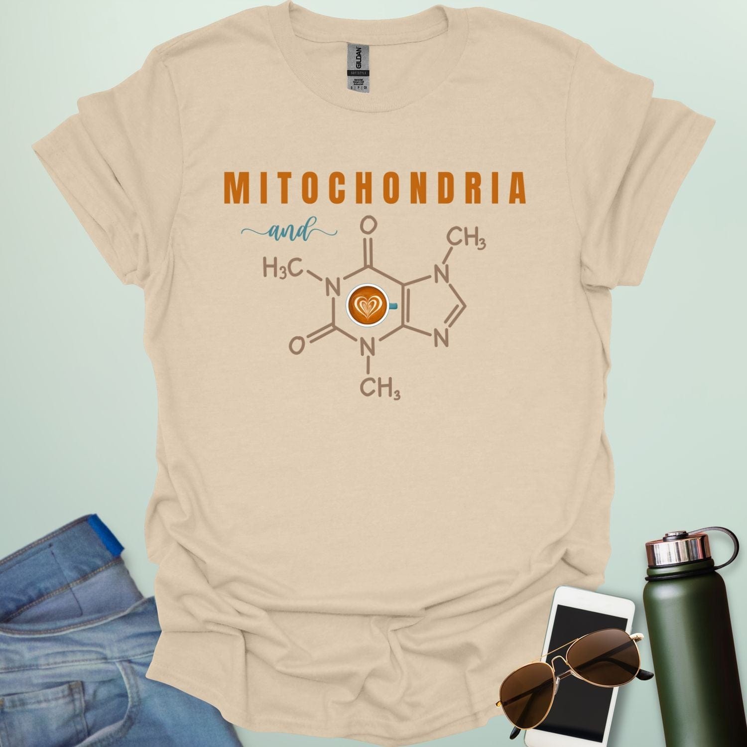 A tan t-shirt with the text 'MITOCHONDRIA and' above a graphic of the caffeine chemical structure with a coffee cup icon.