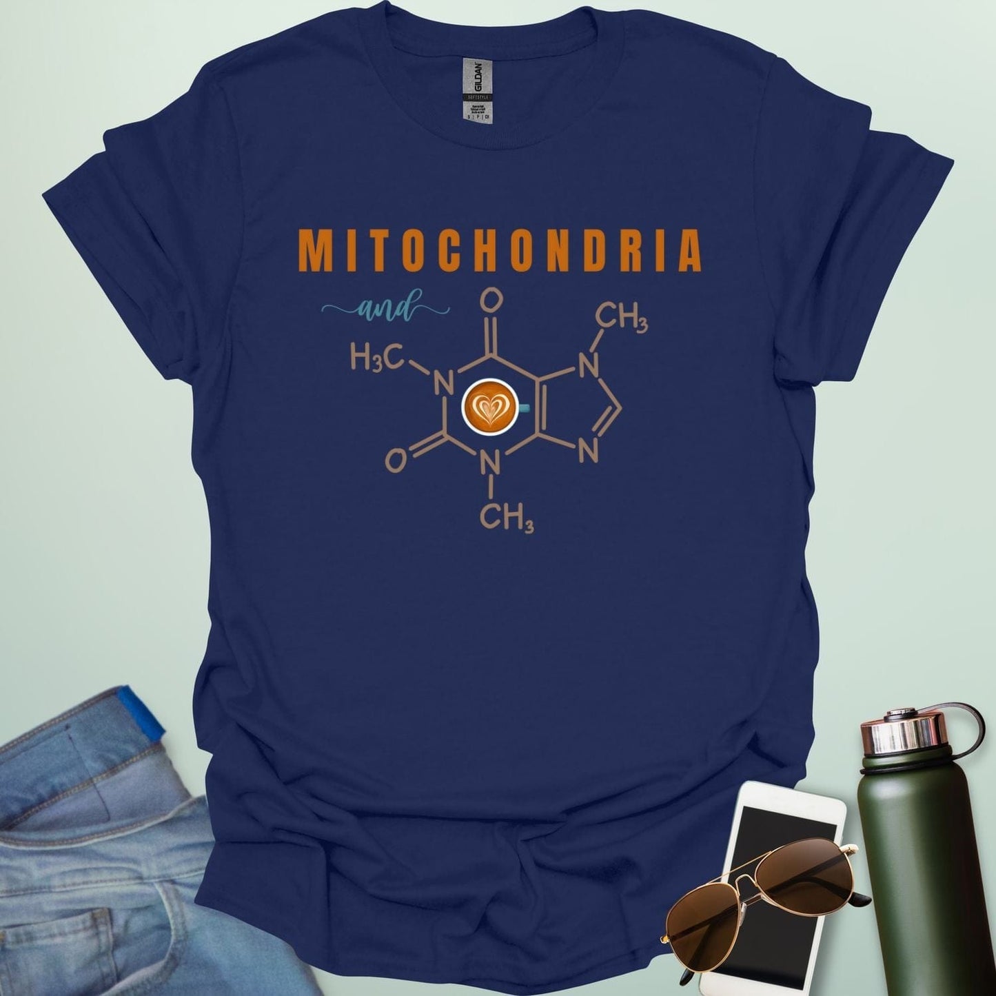 A navy blue t-shirt with the text 'MITOCHONDRIA and' above a graphic of the caffeine chemical structure with a coffee cup icon.