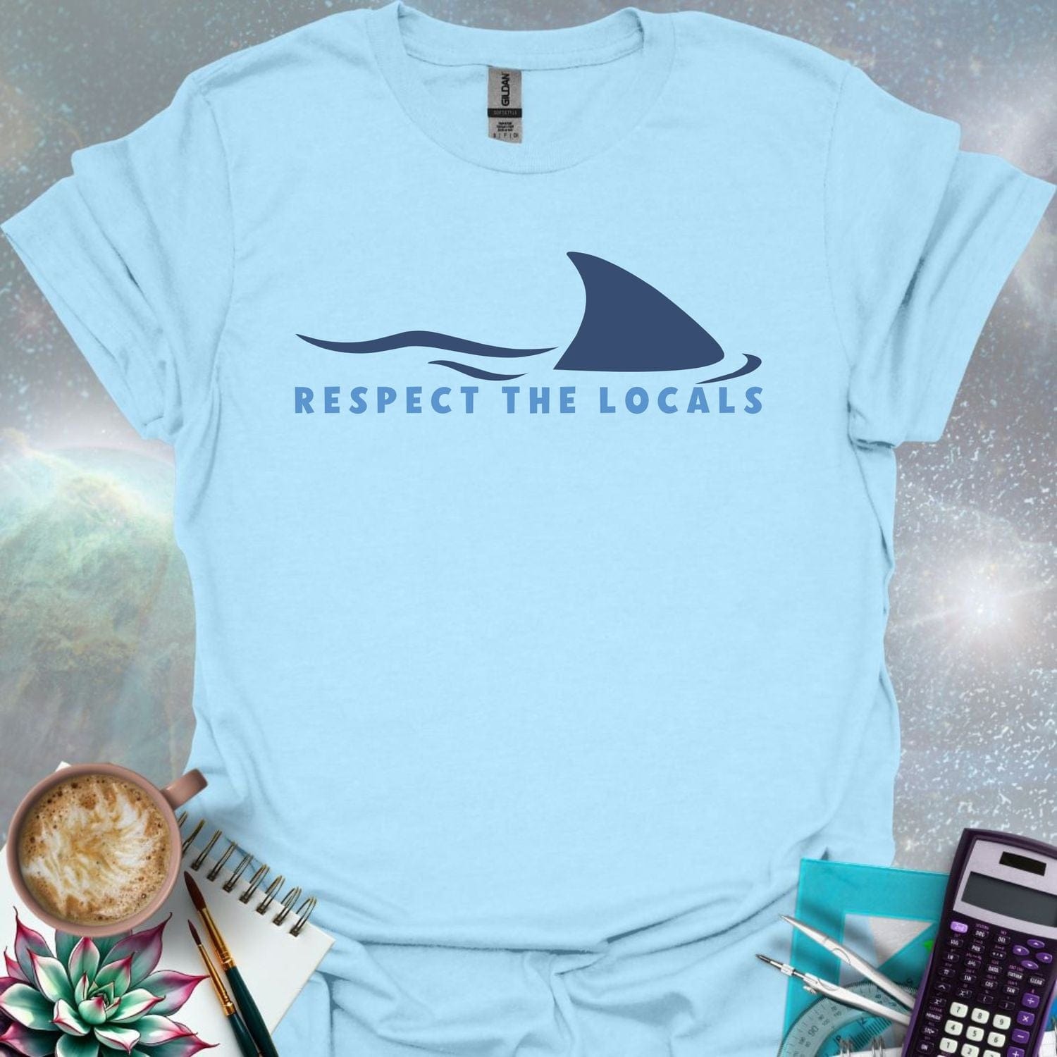 A blue shark fin rising above blue ocean waves, with the text 'RESPECT THE LOCALS' below.