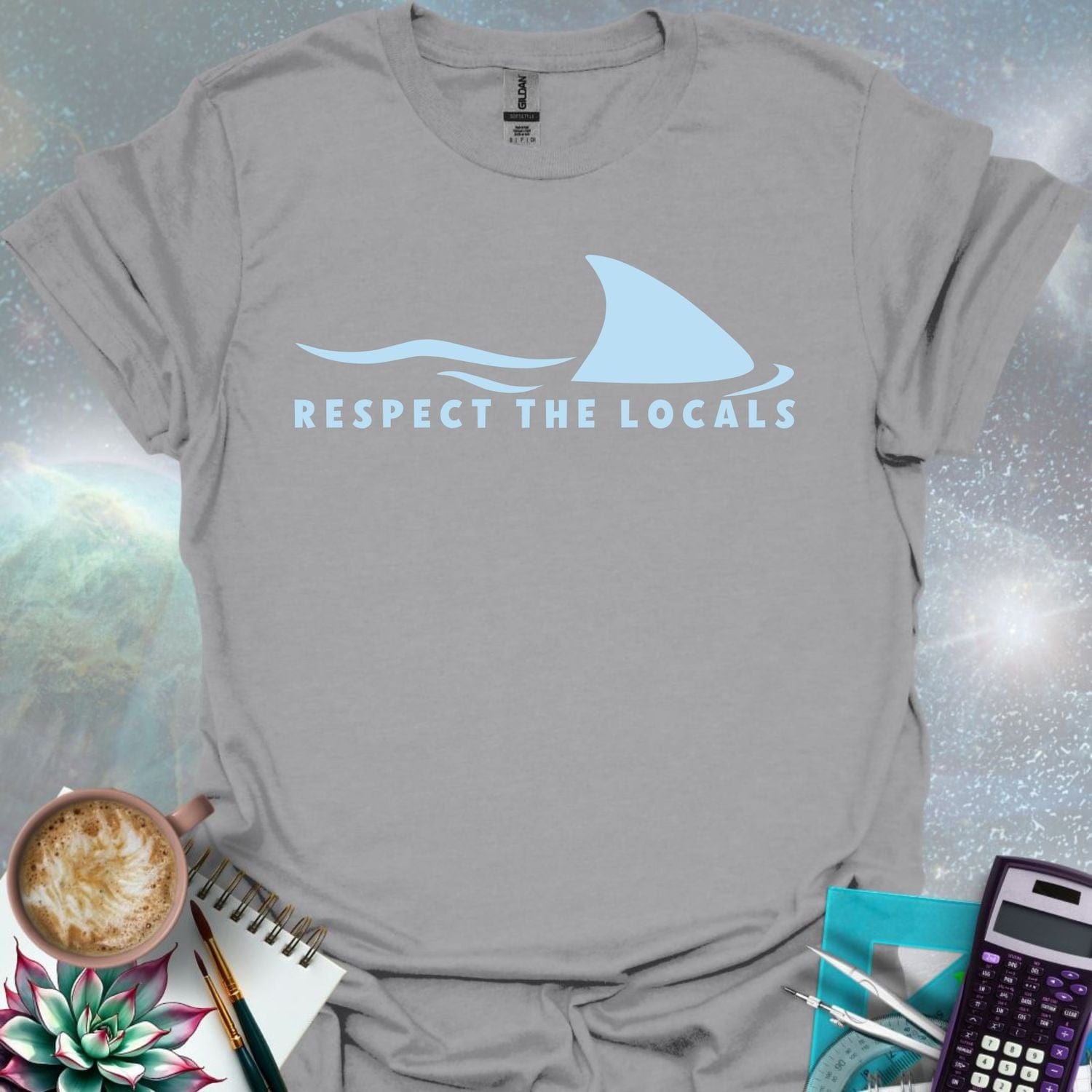 A blue shark fin rising above blue ocean waves, with the text 'RESPECT THE LOCALS' below.