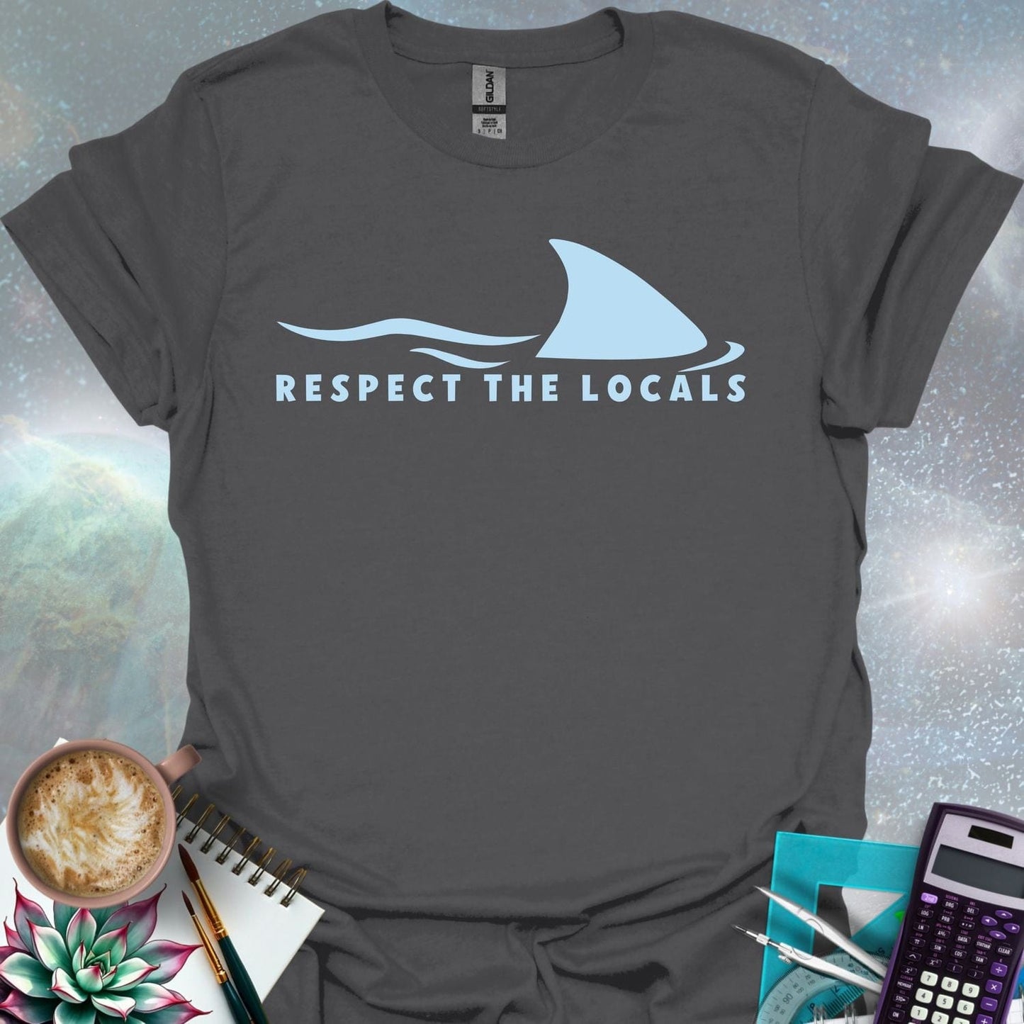 A blue shark fin rising above blue ocean waves, with the text 'RESPECT THE LOCALS' below.