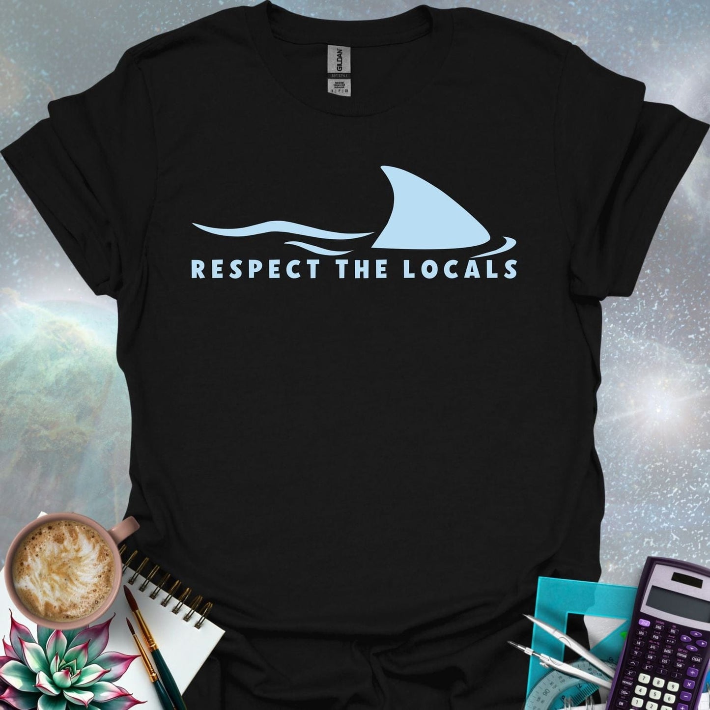A blue shark fin rising above blue ocean waves, with the text 'RESPECT THE LOCALS' below.