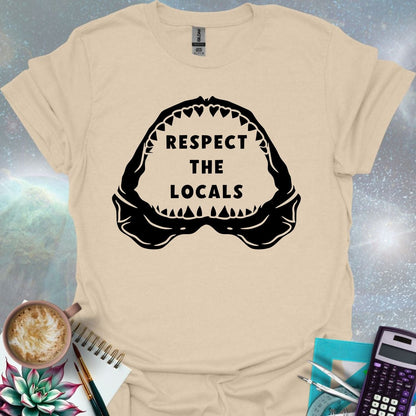 The silhouette of a menacing open shark jaw with sharp teeth, framing the text 'RESPECT THE LOCALS' in the center.