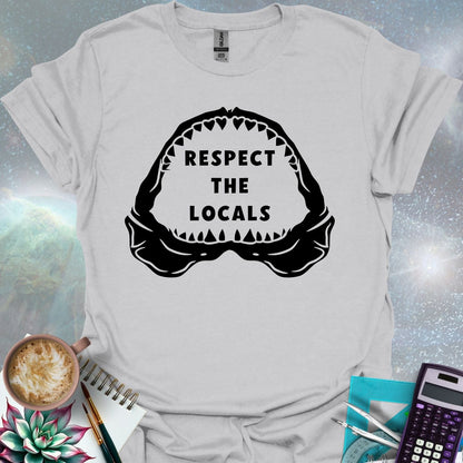 The silhouette of a menacing open shark jaw with sharp teeth, framing the text 'RESPECT THE LOCALS' in the center.