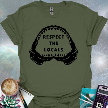 The silhouette of a menacing open shark jaw with sharp teeth, framing the text 'RESPECT THE LOCALS' in the center.