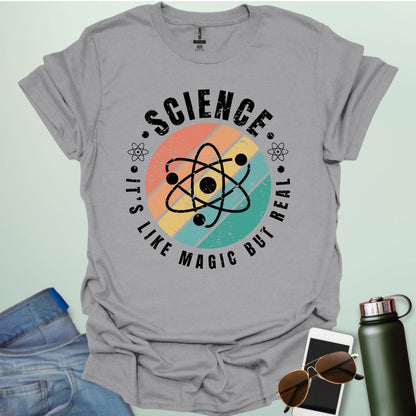 T-shirt with a clean design featuring an atom symbol and the quote 'Science - It's like magic but real'.