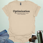 A typography t-shirt design with the word "Optimization" in a bold serif font and "One Hundred Days Later Still Running" in clean sans-serif text.