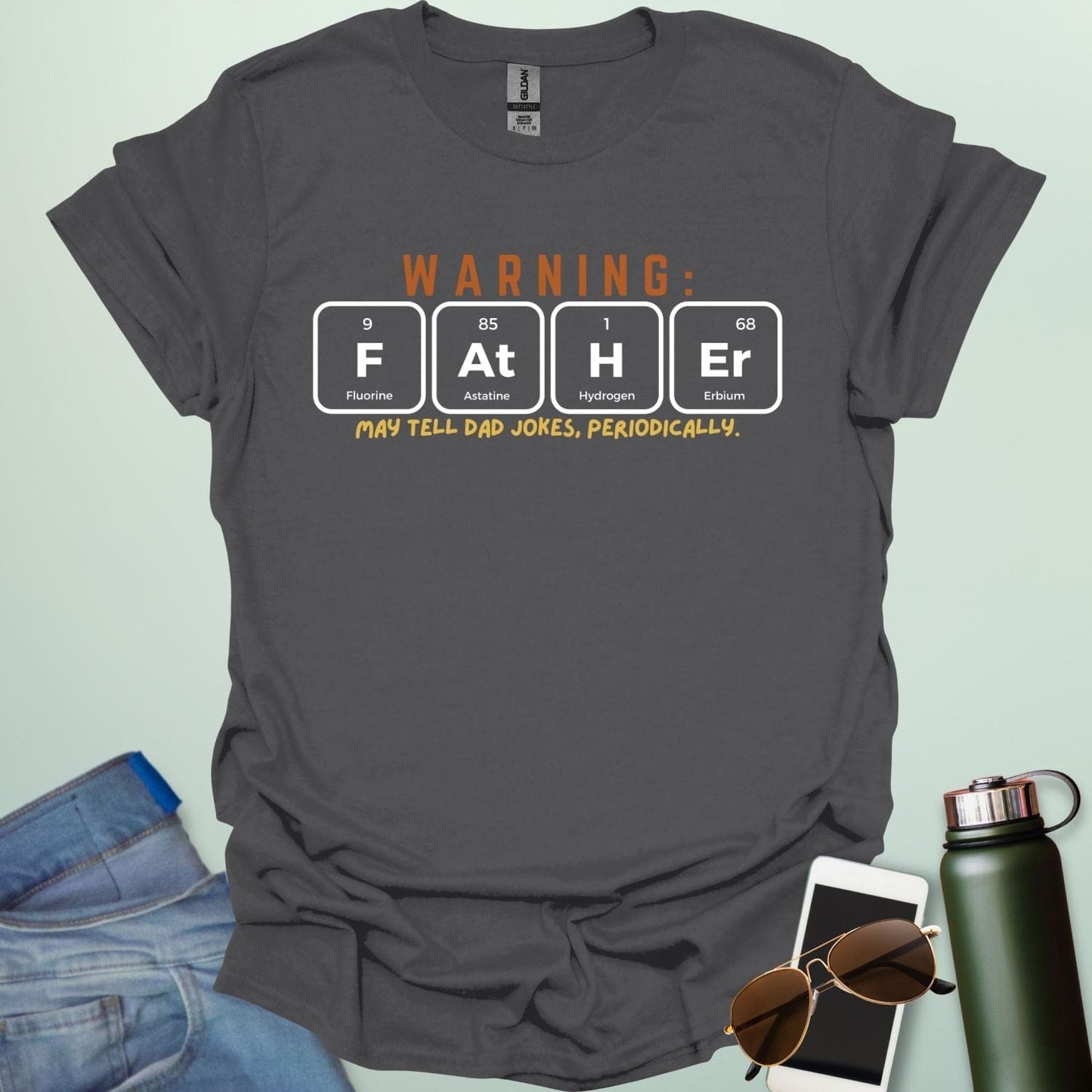 A funny periodic table t-shirt for fathers, using the elements Fluorine, Astatine, Hydrogen, and Erbium to spell 'FAtHEr'. The design says 'WARNING: FATHER MAY TELL DAD JOKES, PERIODICALLY.'